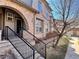 Charming townhouse showcasing a brick archway, black railing, and a well-maintained landscaped entrance at 6725 S Winnipeg Cir # 106, Aurora, CO 80016