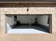 Garage with overhead lighting, gray epoxy floors, and brick exterior at 6725 S Winnipeg Cir # 106, Aurora, CO 80016