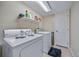Functional laundry room with white appliances and storage shelf for cleaning supplies at 5178 Netherland St, Denver, CO 80249
