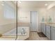 Bathroom featuring a soaking tub with tile surround and vanity with granite counters at 6642 E 135Th Ave, Thornton, CO 80602