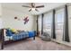 Bedroom with three windows, fan, grey curtains, and carpet at 6642 E 135Th Ave, Thornton, CO 80602