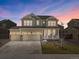 Inviting two-story home featuring a three-car garage, stone accents, and a charming front porch at 6642 E 135Th Ave, Thornton, CO 80602