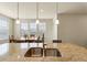Granite counters adorn this kitchen island with pendant lighting and stainless steel faucet at 6642 E 135Th Ave, Thornton, CO 80602