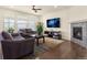 Comfortable living room with hardwood floors, fireplace, ceiling fan, and sunlit windows at 6642 E 135Th Ave, Thornton, CO 80602