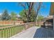 Backyard deck with wooden railings, offering a view of the lawn and mature trees at 7521 S Race St, Centennial, CO 80122