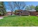 Backyard with a large lawn, patio, shed, mature trees and privacy fence at 7521 S Race St, Centennial, CO 80122