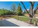 Wooden deck overlooks a backyard with mature trees, lush lawn, and privacy fencing at 7521 S Race St, Centennial, CO 80122