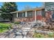 Inviting front entrance with brick accents, stone steps, and a beautifully landscaped front yard with decorative gravel at 7521 S Race St, Centennial, CO 80122