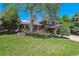 Well-maintained front lawn with mature trees and bushes leading to a charming two-story brick home at 7521 S Race St, Centennial, CO 80122