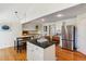 Bright eat-in kitchen features granite counters, stainless appliances, hard wood floors, and island with seating at 7521 S Race St, Centennial, CO 80122