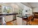 Bright kitchen features granite counters, stainless appliances, hard wood floors, and island with seating at 7521 S Race St, Centennial, CO 80122