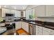 Bright eat-in kitchen features granite counters, stainless appliances, hard wood floors, and ample cabinetry at 7521 S Race St, Centennial, CO 80122