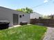 Backyard with a patch of green grass, privacy fence, and small patio area at 1568 Wolff St, Denver, CO 80204
