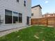 The backyard provides a private outdoor retreat with green grass and a wooden fence for added seclusion at 1568 Wolff St, Denver, CO 80204