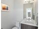 Half bath with geometric wallpaper, floating vanity and bright mirror at 1568 Wolff St, Denver, CO 80204