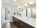 Stylish bathroom featuring double sinks, wood cabinets, and a doorway to a bright, airy bedroom at 1568 Wolff St, Denver, CO 80204