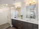 Modern bathroom featuring double vanity, sleek mirrors, and glass enclosed shower at 1568 Wolff St, Denver, CO 80204