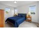 Bright bedroom features natural light, bedside tables, and a blue-themed bed at 1568 Wolff St, Denver, CO 80204