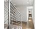 Hallway with hardwood floors, modern railing, and views to the living room at 1568 Wolff St, Denver, CO 80204