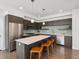 Modern kitchen with a stainless steel refrigerator and a large center island with wooden stools at 1568 Wolff St, Denver, CO 80204
