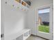 Bright mud room with white walls and shelving, a bench, and access to the backyard at 1568 Wolff St, Denver, CO 80204