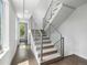 Carpeted staircase with modern metal railing and large windows providing natural light at 1568 Wolff St, Denver, CO 80204