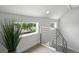 Bright upper landing with large windows, modern railings and a view to mature trees outside at 1568 Wolff St, Denver, CO 80204