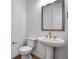 Stylish half bathroom features a pedestal sink with brass fixtures and modern design, perfect for guests at 3324 N Haleyville Ct, Aurora, CO 80019
