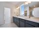 Bathroom featuring double sinks, with gray cabinetry, quartz counters and decorative lighting at 3324 N Haleyville Ct, Aurora, CO 80019