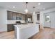 Well-lit kitchen boasts gray cabinets, stainless appliances, a quartz island, and wood floors at 3324 N Haleyville Ct, Aurora, CO 80019