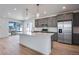 Bright kitchen features gray cabinets, stainless appliances, large island, and wood flooring at 3324 N Haleyville Ct, Aurora, CO 80019