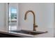 Close-up of gold faucet and kitchen sink, adjacent to a window with neighborhood views at 3324 N Haleyville Ct, Aurora, CO 80019