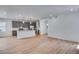 Open floor plan showcasing a modern kitchen adjacent to a spacious living area and wood flooring at 3324 N Haleyville Ct, Aurora, CO 80019