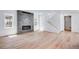 Open living room with fireplace feature wall, white walls, and light wood flooring at 3324 N Haleyville Ct, Aurora, CO 80019