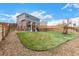Lush backyard with green grass, stone landscaping, a play structure, and tiered retaining walls at 24525 E Wagon Trail Ave, Aurora, CO 80016