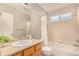 Well-lit bathroom with a shower and tub combination, a window, and a vanity with storage at 24525 E Wagon Trail Ave, Aurora, CO 80016