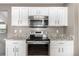 Modern kitchen with white cabinetry, granite countertops, and stainless steel appliances for a sleek look at 24525 E Wagon Trail Ave, Aurora, CO 80016