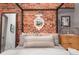 Stylish bedroom showcasing a brick accent wall, a four-poster bed, and a decorative mirror at 2500 Walnut St # 106, Denver, CO 80205