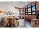 Inviting living room featuring exposed brick, large windows, hardwood floors and comfortable seating arrangements at 2500 Walnut St # 106, Denver, CO 80205