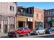 A charming block features a mix of brick and colorful buildings with vibrant businesses and street parking at 2500 Walnut St # 106, Denver, CO 80205