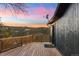 A back deck features wood railings and a stunning view of the colorful sunset and mountains at 11725 Tomahawk Trl, Conifer, CO 80433