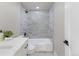 Stylish bathroom with marble tile, a modern shower head, and a sleek vanity at 11725 Tomahawk Trl, Conifer, CO 80433