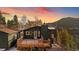 An exterior view of the home from the rear deck at sunset at 11725 Tomahawk Trl, Conifer, CO 80433