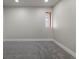 A large and empty room with carpet flooring and a small window at 11725 Tomahawk Trl, Conifer, CO 80433