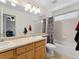 Well-lit bathroom featuring a double sink vanity, toilet, shower and tub combination at 7869 Solstice Way, Castle Rock, CO 80108