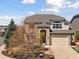 Charming two-story home featuring a brick facade, manicured landscaping, and a two-car garage at 7869 Solstice Way, Castle Rock, CO 80108