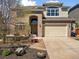Inviting front entrance with a brick facade, arched doorway, and a well-maintained lawn at 7869 Solstice Way, Castle Rock, CO 80108