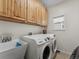 Functional laundry room featuring a washing machine, dryer, sink, and built-in cabinets at 7869 Solstice Way, Castle Rock, CO 80108