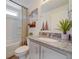 Well-lit bathroom featuring granite countertops, modern fixtures, and a shower with curtain at 10366 Uvalda Ct, Commerce City, CO 80022