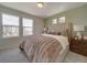 Comfortable bedroom featuring large windows, a plush bedspread, and a neutral color palette at 10366 Uvalda Ct, Commerce City, CO 80022